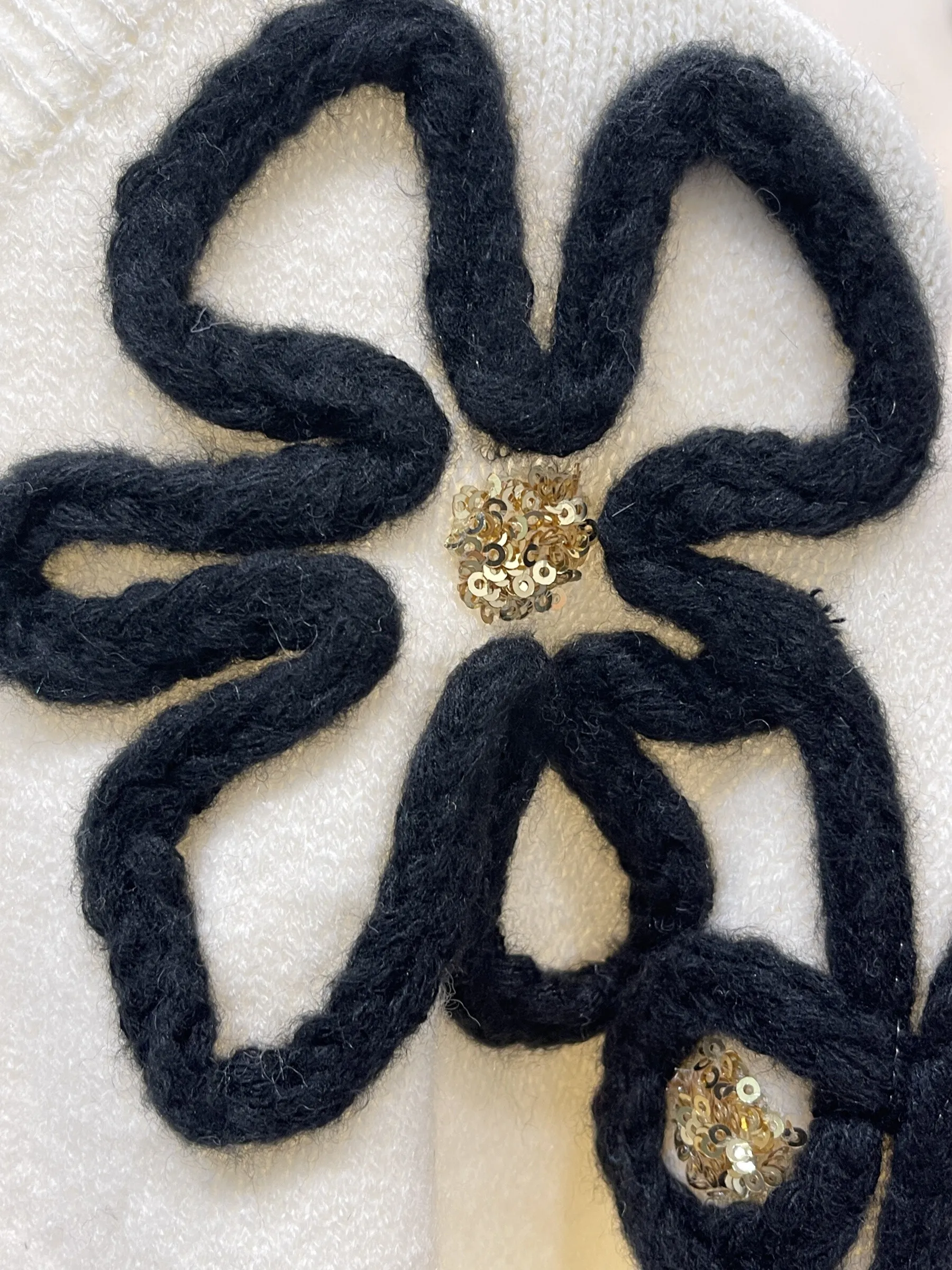 Langarmpullover mit geprägten Blumenmustern und Perlen.